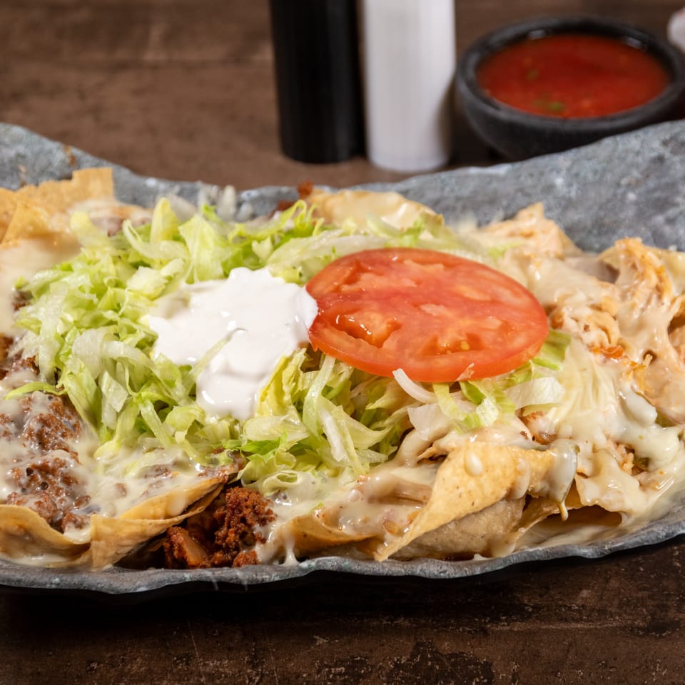 Reyes Mexican Grill nachos with ground beef, cheese, lettuce, sour cream, and tomato.